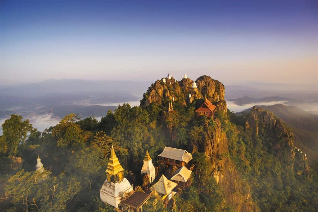 กลุ่มเจดีย์สีขาวบนยอดเขาที่วัดพุทธบาทสุทธาวาส ที่เที่ยวลำปางชมวิวหุบเขา
