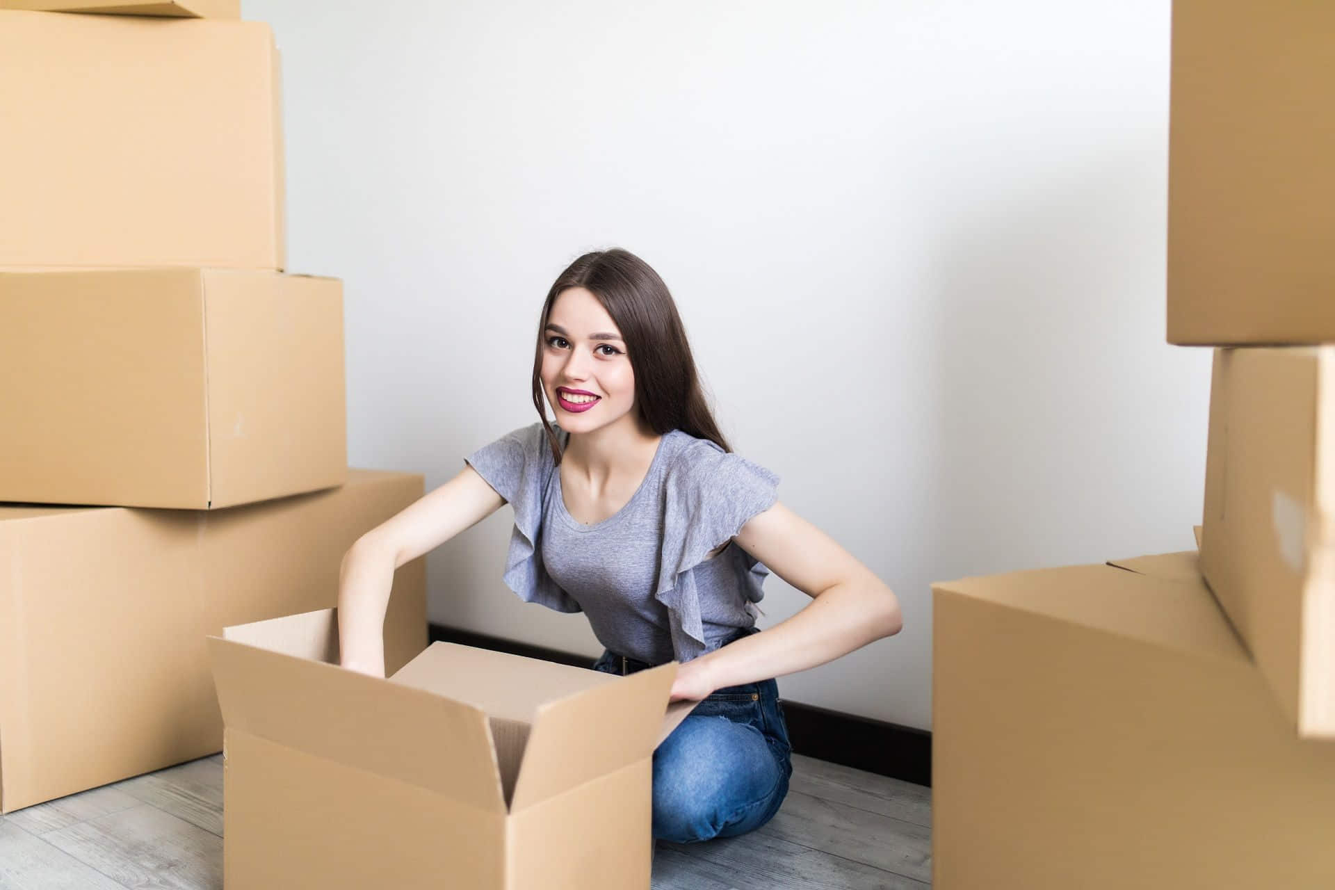 An excited woman unpacks a delivered order. Online shopping for