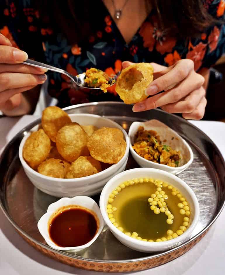 Street food in KL: woman eating pani puri at Namaste India